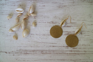 Gold trimmed cowrie shell earrings with raw brass charms