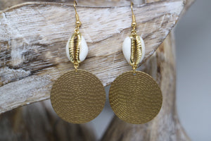 Gold trimmed cowrie shell earrings with raw brass charms