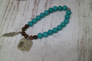 Turquoise and wood beaded bracelet with rustic silver 'dreaming of the sea' charm and boho feather charm