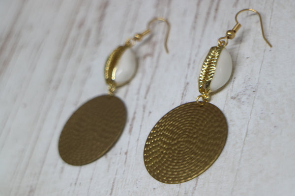 Load image into Gallery viewer, Gold trimmed cowrie shell earrings with raw brass charms
