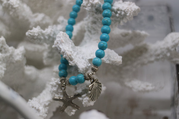 Load image into Gallery viewer, Blue Howlite bead bracelet with a silver starfish and shell charm
