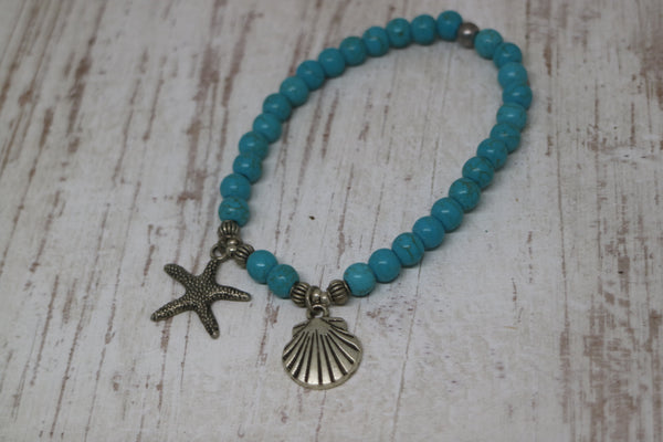 Load image into Gallery viewer, Blue Howlite bead bracelet with a silver starfish and shell charm
