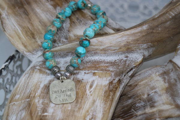 Load image into Gallery viewer, Blue Sea Sediment Jasper beaded bracelet with rustic silver &#39;dreaming of the sea&#39; charm

