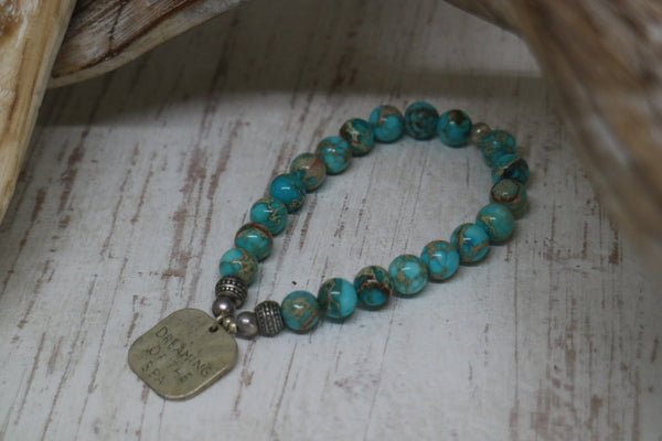 Load image into Gallery viewer, Blue Sea Sediment Jasper beaded bracelet with rustic silver &#39;dreaming of the sea&#39; charm
