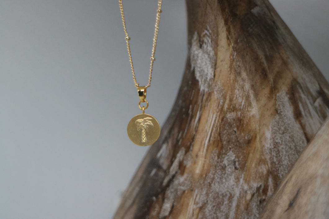 Gold palm tree coin necklace