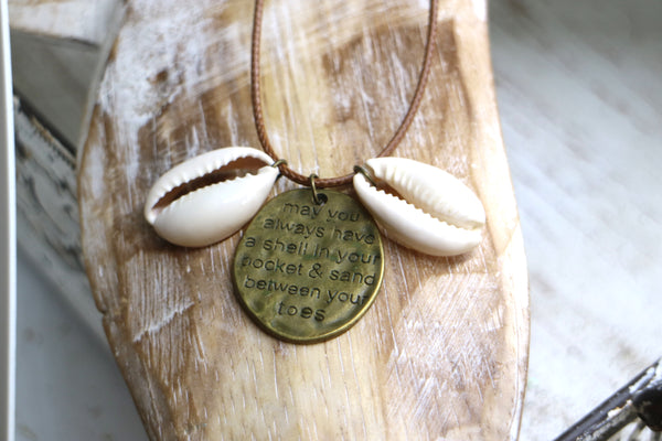 Load image into Gallery viewer, Cowrie shell and engraved antique bronze pendant on a brown leather cord necklace
